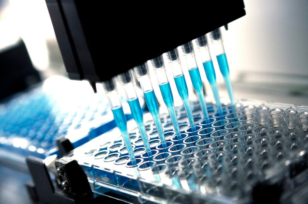 Robotic multichannel pipette dispensing blue liquid for pharmaceutical research and testing.